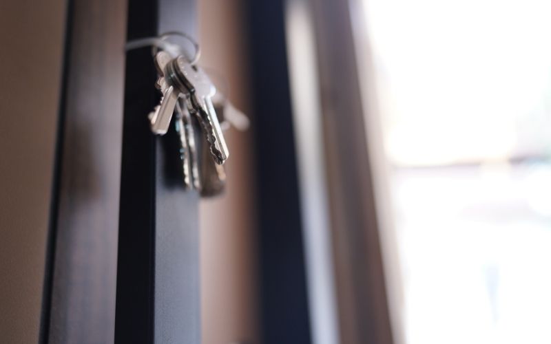 Trousseau de clés sur la serrure d'une porte sombre